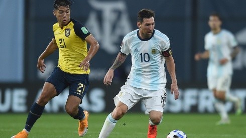 Messi traslada la pelota. Detrás suyo, Caicedo intenta contenerlo.